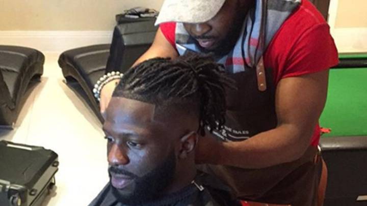 Nikky Okyere cortando el pelo al futbolista Bakary Sako.