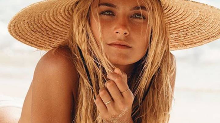 Bridget Malcolm con sombre en la playa.