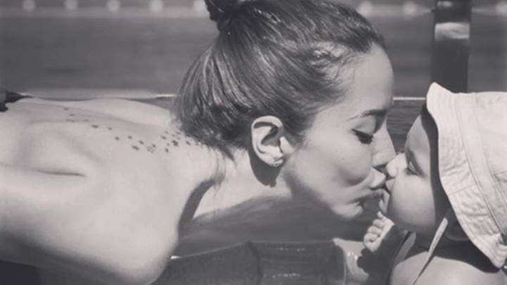 Aurah Ruiz dando un beso a su hijo Nyan mientras está en una piscina de plástico. Foto Instagram @aurah.ruiz