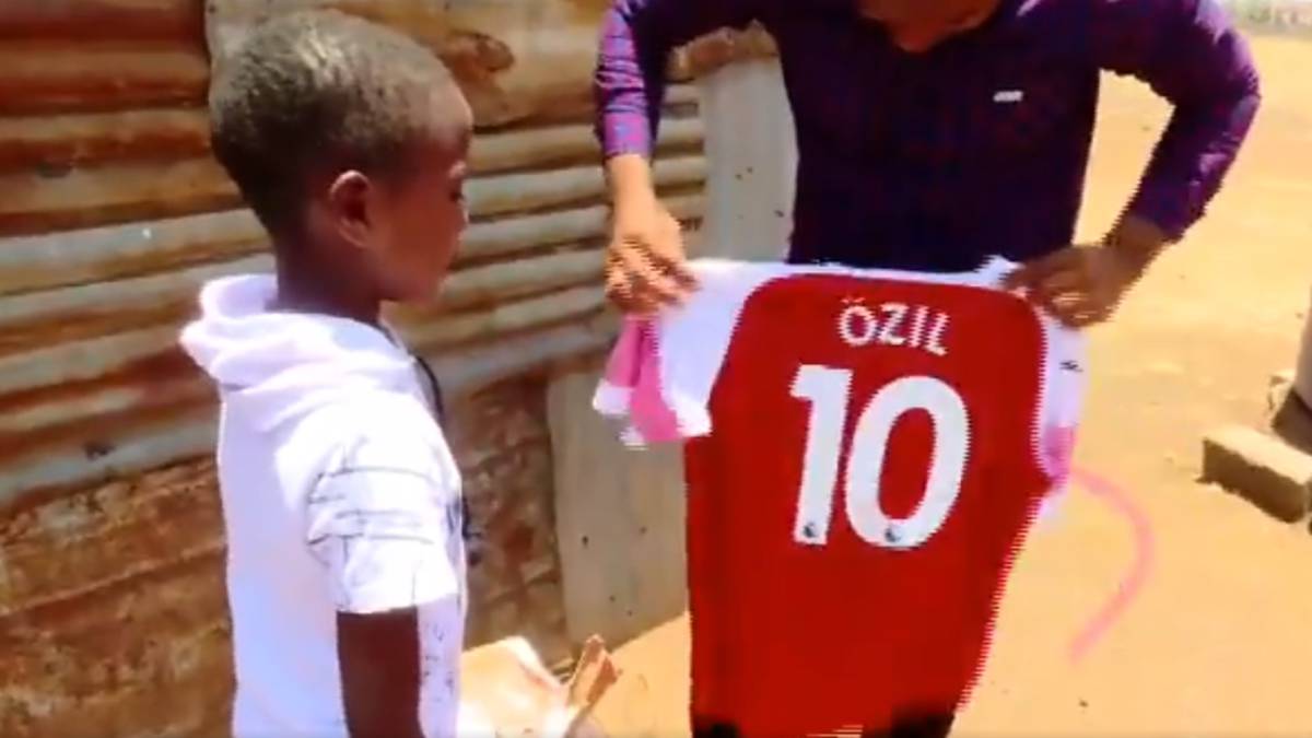 Lawrence Masira, un niño keniano admirador de Mesut Özil, al recibir de él una camiseta del Arsenal. Captura Twitter
