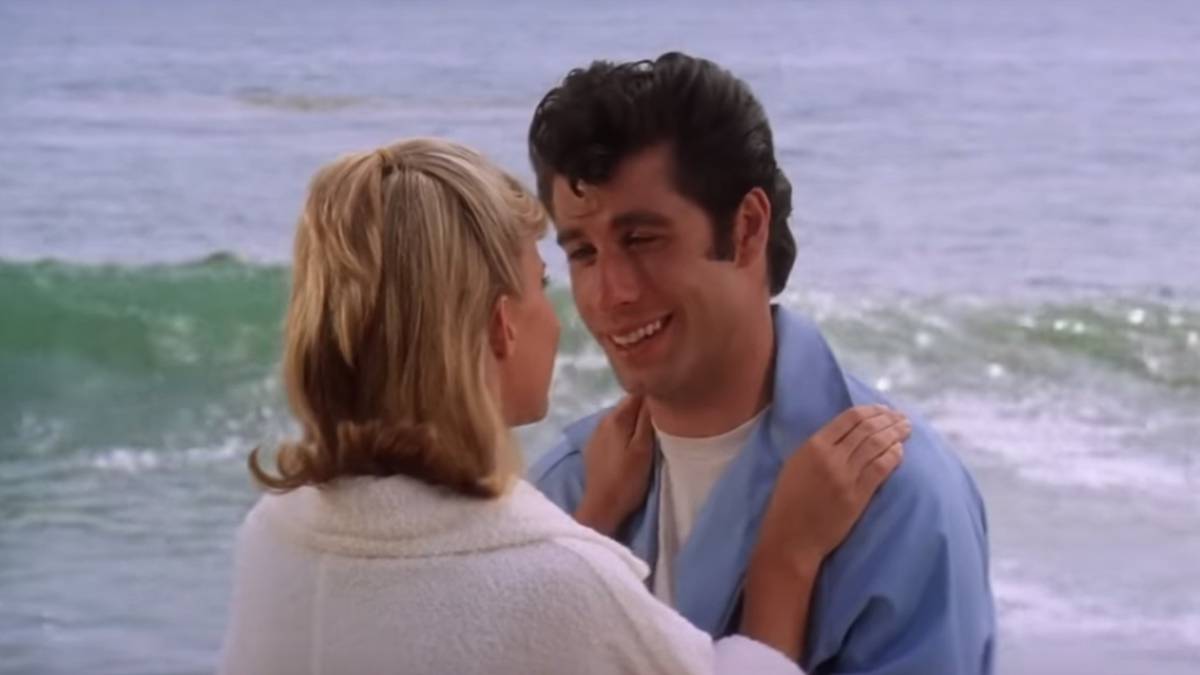 Imagen del principio de la película de 'Grease': de John Travolta (Danny Zucco) mirando a Sandy Olsson (Olivia Newton-John) en la playa. Captura Youtube
