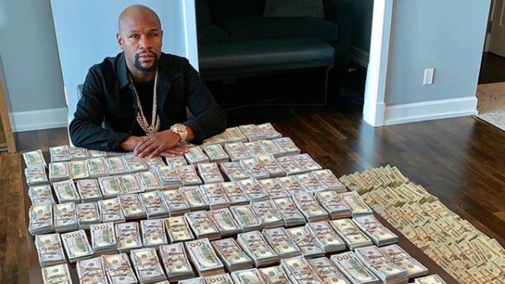 El exboxeador estadounidense Floyd Mayweather sentado en una mesa llena de fajos de billetes. Foto Instagram @floydmayweather