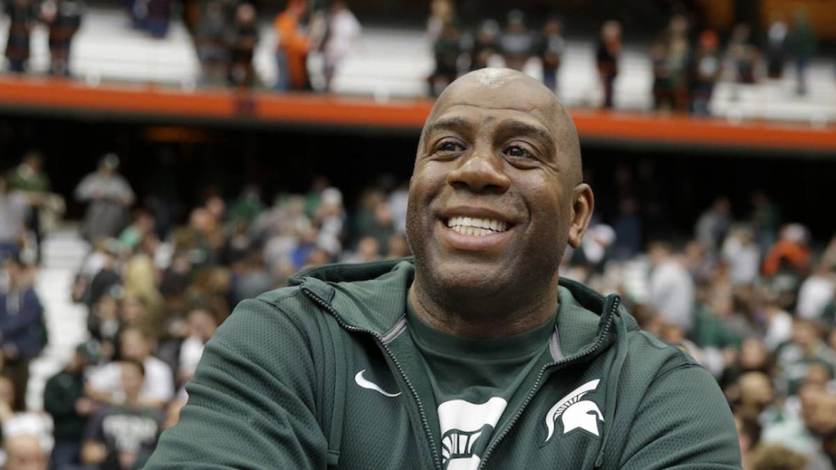 Earvin Johnson sonríe mientras usa una sudadera de los Spartans de Michigan State
