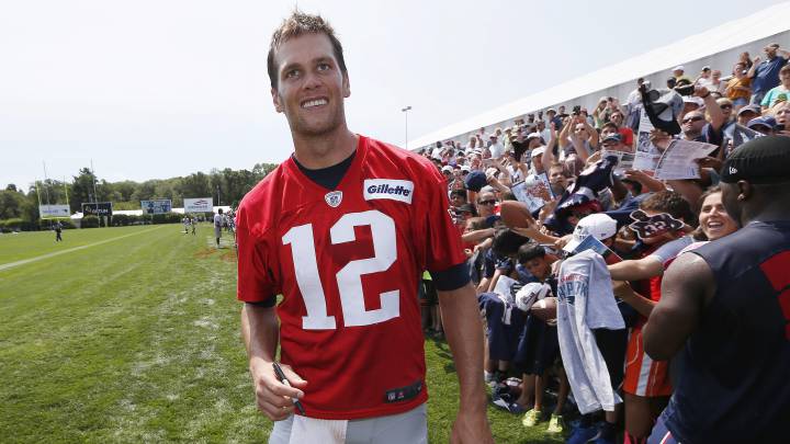 Tom Brady sonríe después de un entrenamiento, firma objetos de fans de los Patriots