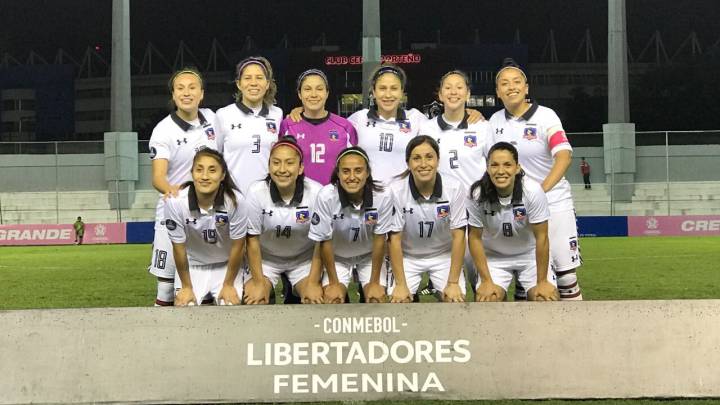Equipo femenil de fútbol, vestidas con uniforme blanco y la arquera en rosa
