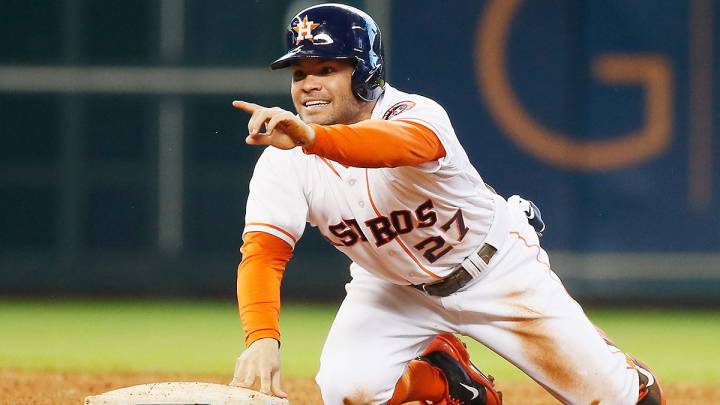 José Altuve señala algo mientras se apoya en una base