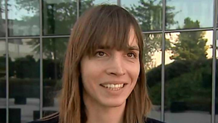 Mujer sonriendo, tiene sueter negro cabello suelto
