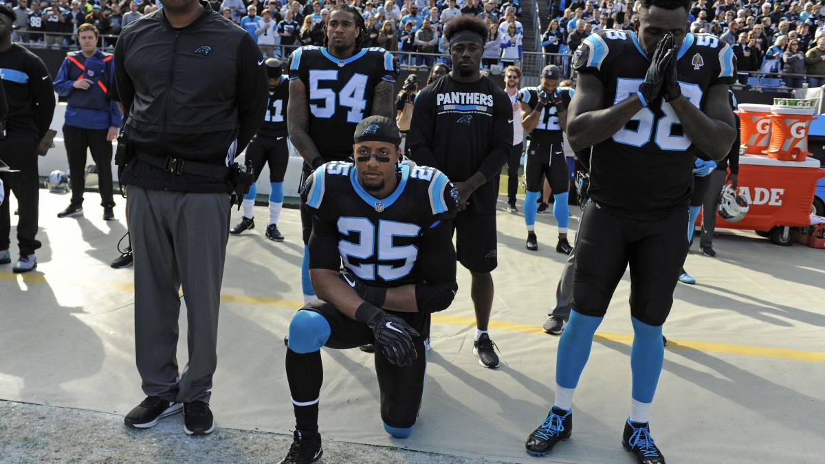 Eric Reid hincado en partido de Panthers