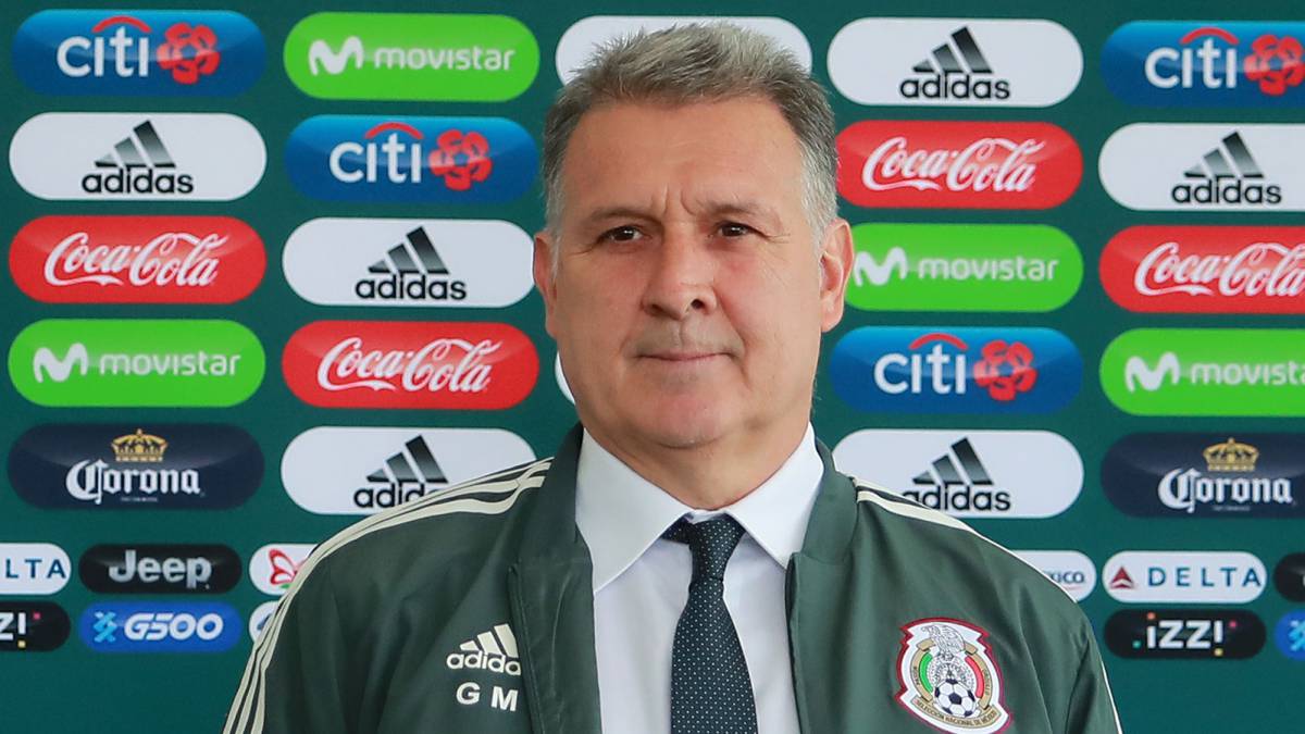 Gerardo "Tata" Martino poses with a training jacket of the Mexican national football team during his presentation as new coach of the squad