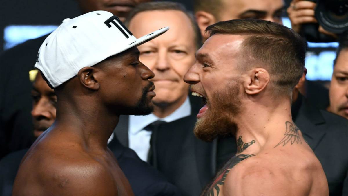 Boxer Floyd Mayweather Jr. (L) and UFC lightweight champion Conor McGregor face off during their official weigh-in at T-Mobile Arena on August 25, 2017 in Las Vegas, Nevada.
