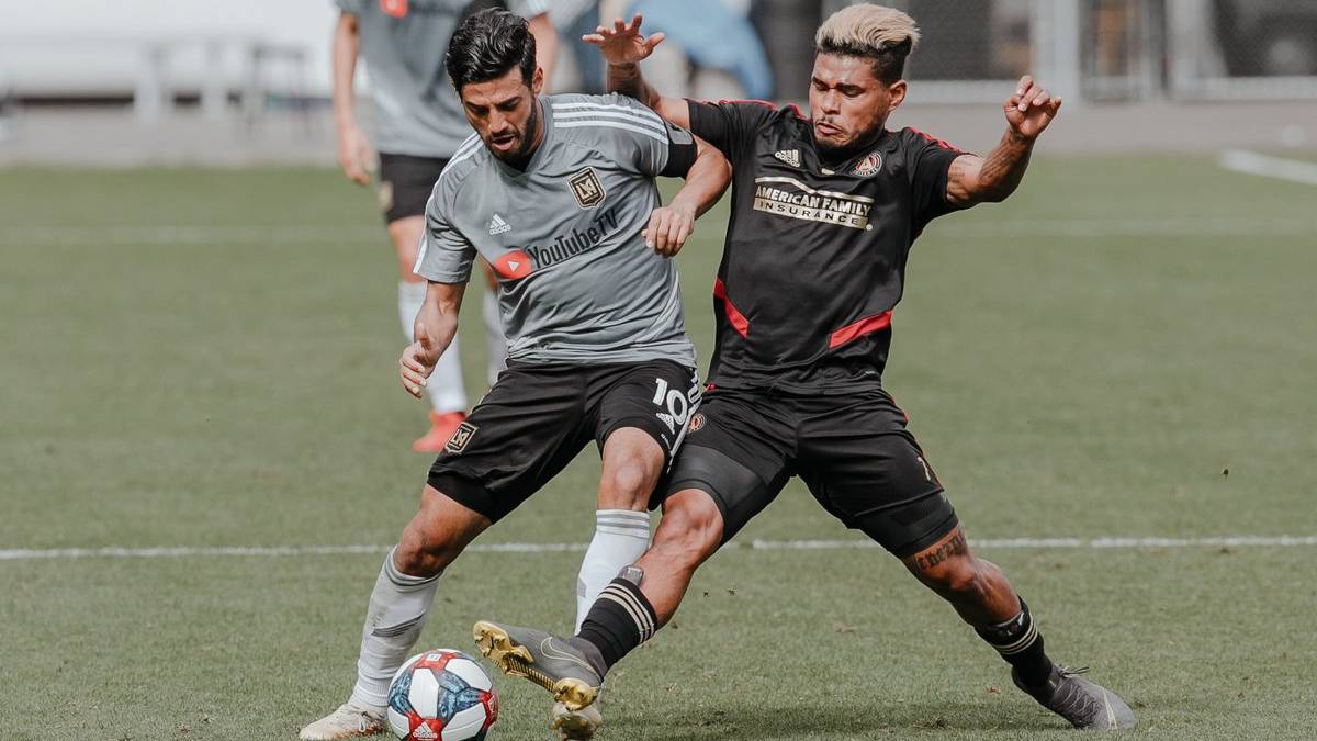 Carlos Vela peleando un balón con Josef Martínez