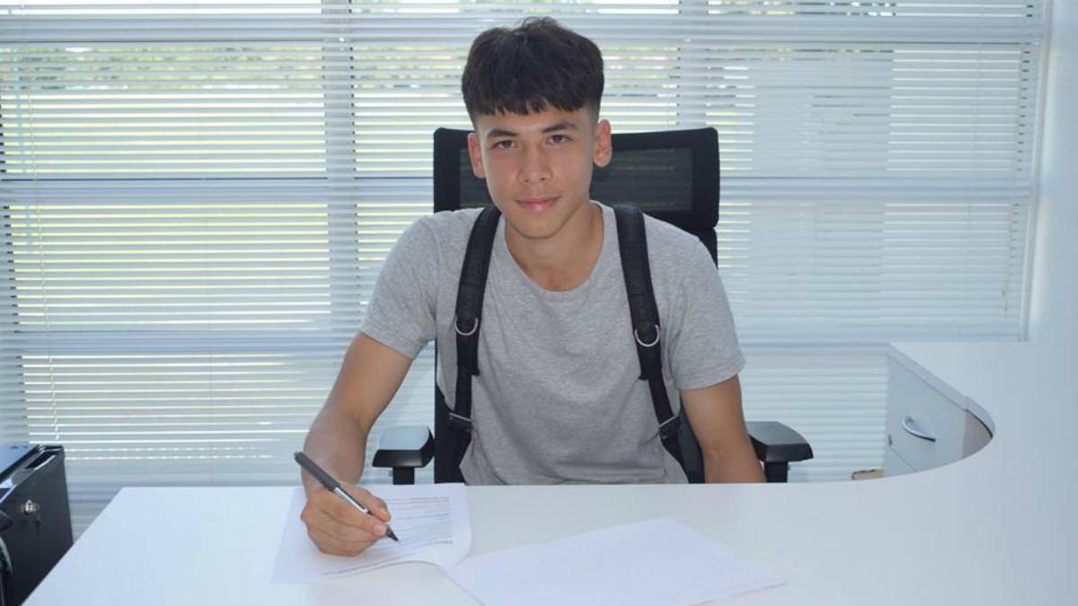 Ben Davis signing his contract with the English team Fulham FC