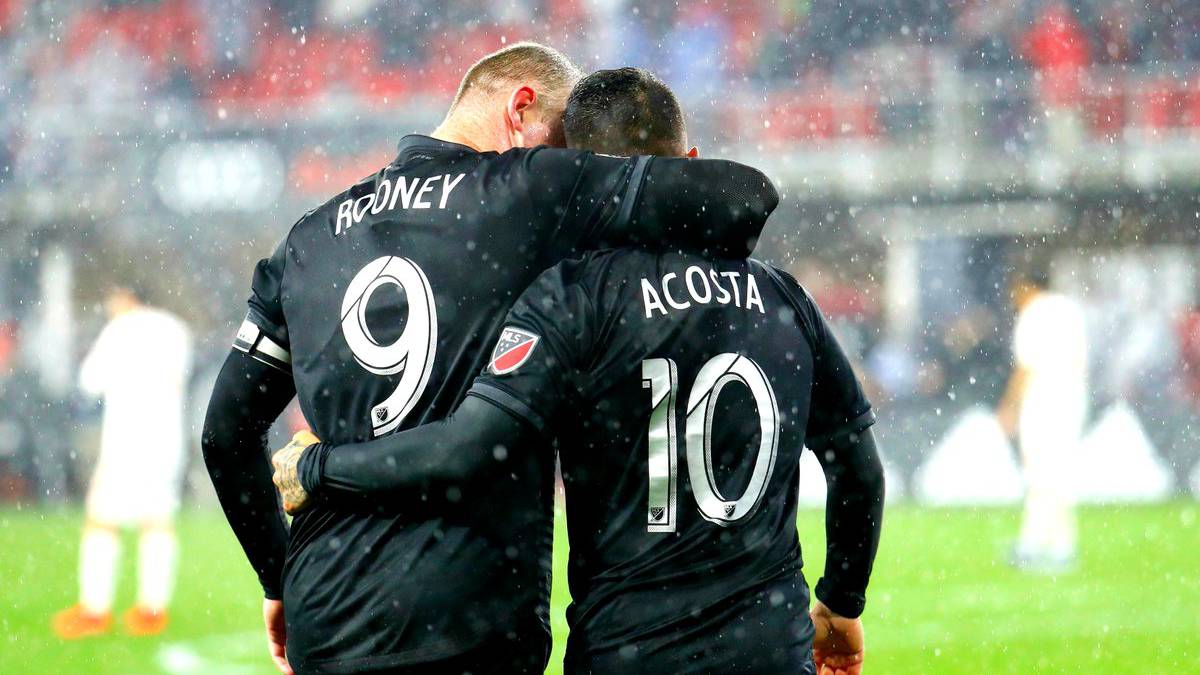 Rooney y Acosta abrazandoce