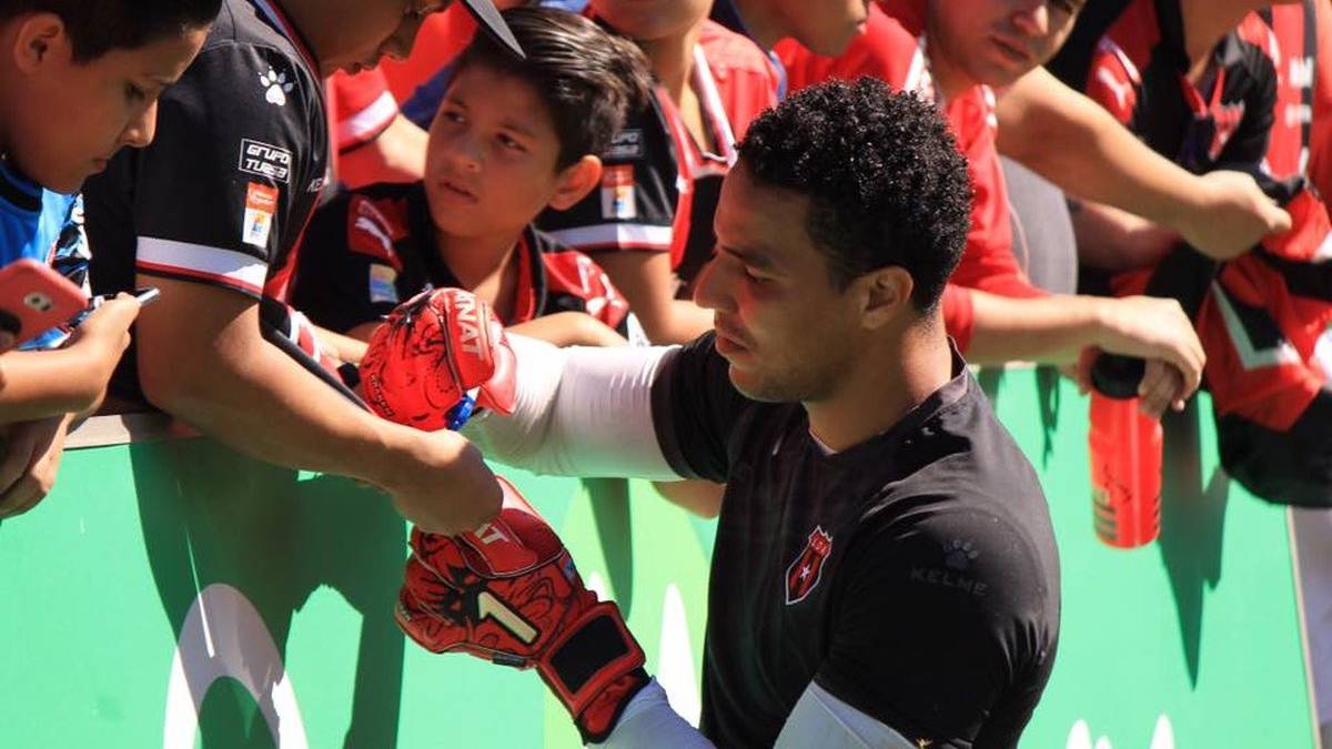 Esteban Alvarado firmando autógrafos con Alajuelense