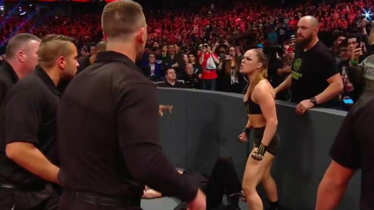 Ronda Rousey peleando con oficiales de WWE
