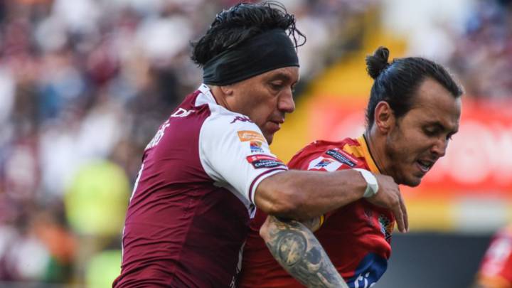 Jugadores de Saprissa y Herediano disputan un balón.