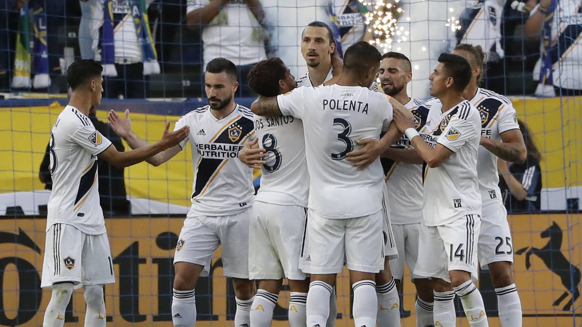 Los Angeles Galaxy forward Zlatan Ibrahimovic, center, is hugged by teammates after scoring against the Portland Timbers