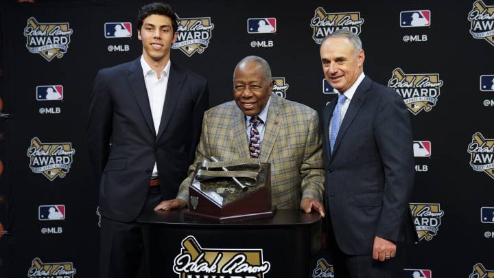 Yelich recibe el trofeo de las manos de Hank Aaron y Rob Manfred