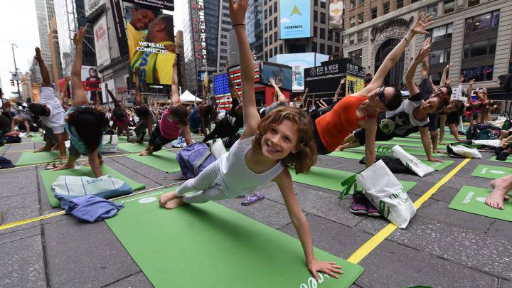 Personas practican yoga en Times Square