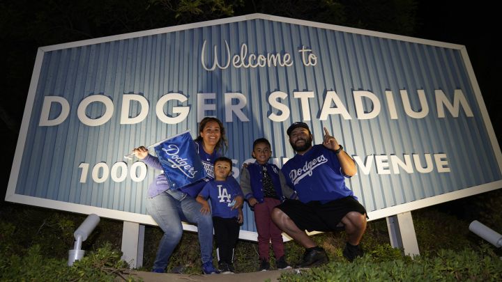 Aficionados posan frente a anuncio de Dodger Stadium