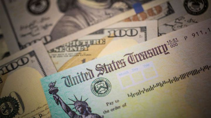Cheque de estímulo de Estados Unidos sobre billetes de 100 dólares estadounidenses