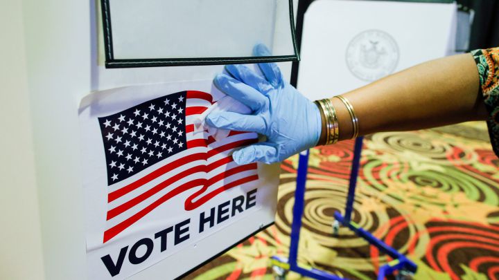 Un trabajador electoral desinfecta una cabina en el centro de votación en la ciudad de Nueva York