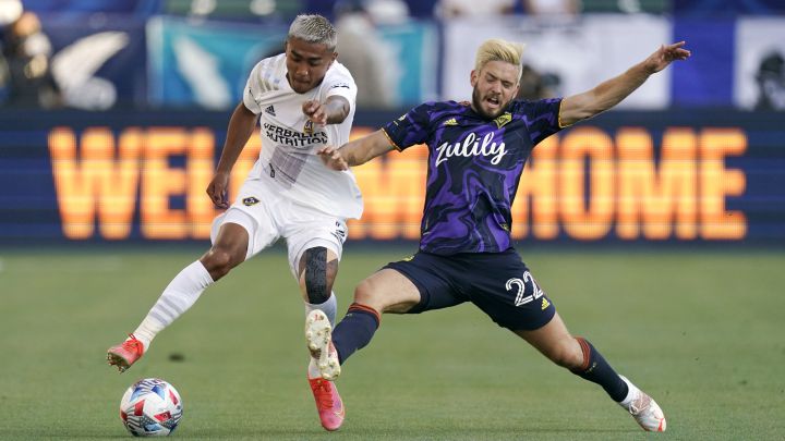 Julian Araujo y Kelyn Rowe peleando por el balón en duelo de LA Galaxy ante Seattle Sounders.