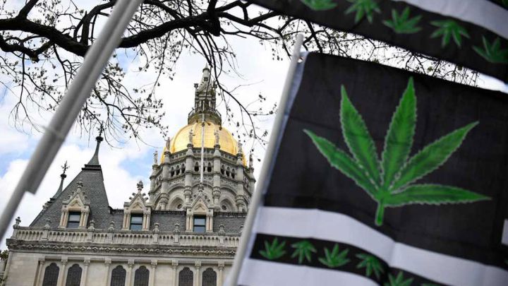 Capitolio del estado de Connecticut y bandera con una hoja de marihuana (cannabis)