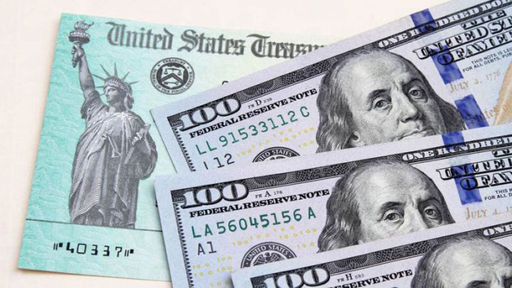 Cheque de estímulo de USA y tres billetes de cien dólares estadounidenses