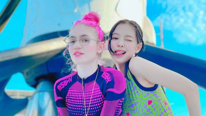 Grimes y Jennie, integrante de BLACKPINK, posando frente a un cohete de SpaceX