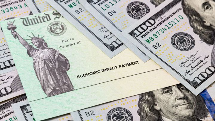 Cheque de estímulo estadounidense y billetes de 100 dólares estadounidenses
