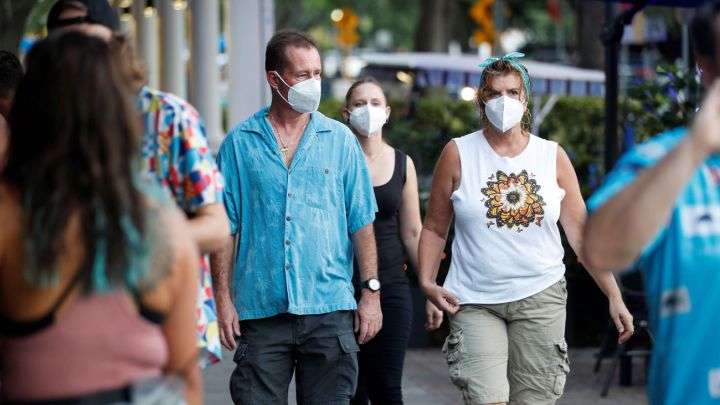 Personas con mascarilla caminando