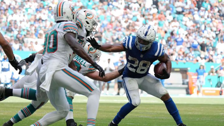 Los defensivos de los Dolphins intentan detener a Jonathan Taylor.