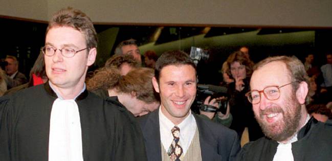 Jean-Marc Bosman, flanqueado por sus abogados Luc Misson y Jean-Louis Dupont, sonriendo en el Tribunal Europeo de Justicia, el 15 de diciembre de 1995.