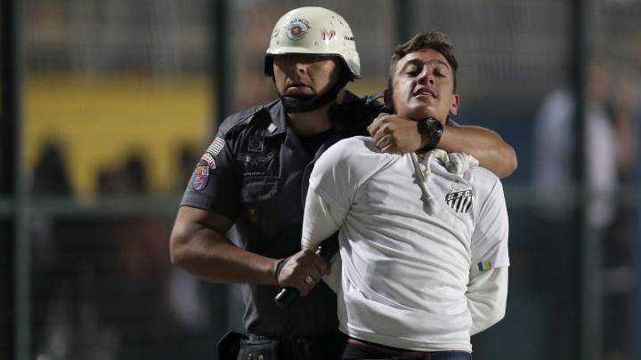 Se alcanzaba el minuto 85 de juego cuando varios petardos cayeron al terreno de juego y cientos de aficionados intentaron invadirlo ante la policía.