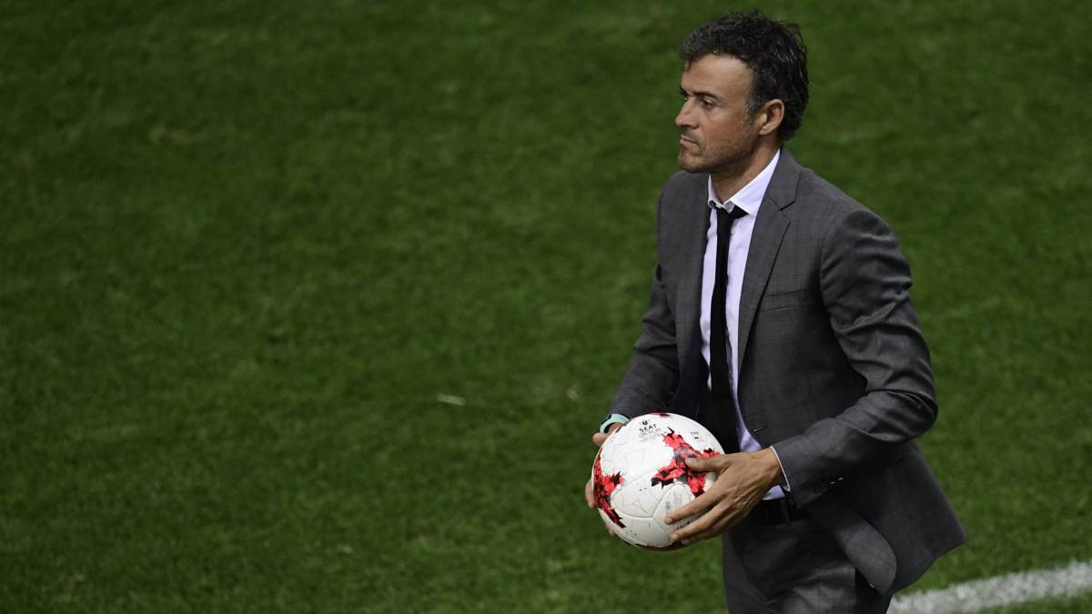 Luis Enrique, durante un partido del Barcelona, sujeta un balón con las manos.