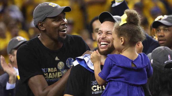 Kevin Durant y Stephen Curry bromean con la hija de este tras ganar el anillo de 2017.