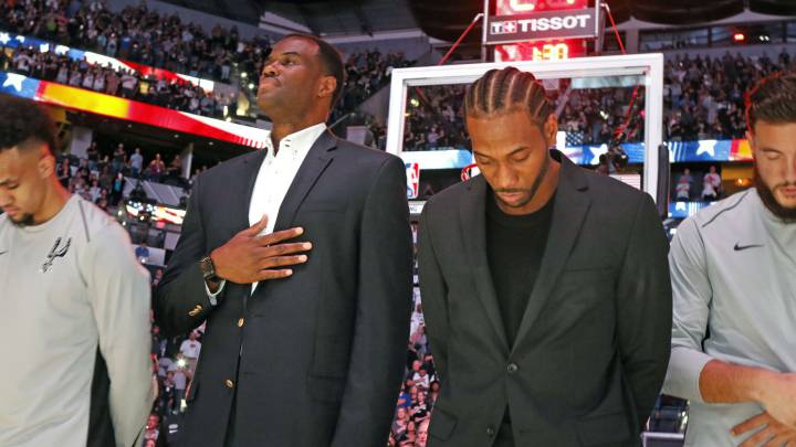 Kawhi Leonard, junto a Dvaid Robinson, escucha el himno estadounidense durante un partido de los Spurs esta temporada.