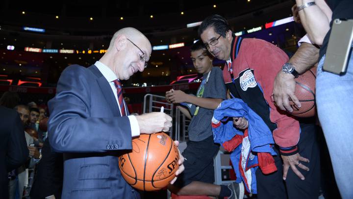 Adam Silver, comisionado de la NBA, firma un balón a un aficionado.