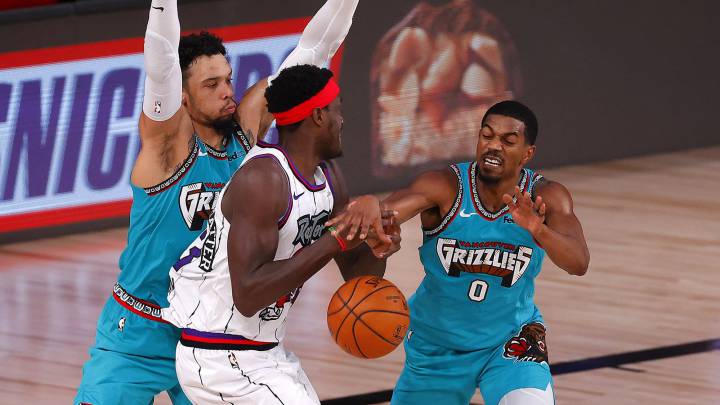 Pascal Siakam lucha contra dos rivales durante el partido de la NBA que ha enfrentado a Toronto Raptors y Memphis Grizzlies
