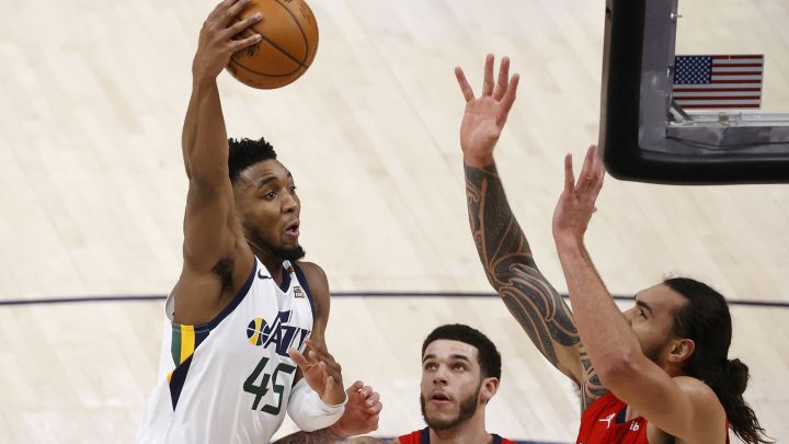 Donovan Mitchell anota ante la defensa de Steven Adams y la mirada de Lonzo Ball durante el Utah Jazz - New Orleans Pelicans.