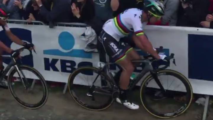 Peter Sagan arrastra la chaqueta de un espectador con su brazo izquierdo durante la disputa del Tour de Flandes.