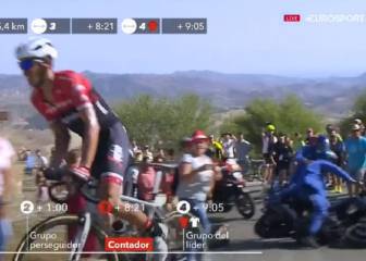 Un policía tira de un empujón a un espectador y una moto