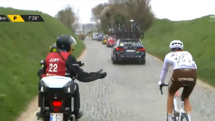 Los comisarios le comunican su descalificación a Michael Schär en el Tour de Flandes 2021 tras darle un bidón a un aficionado fuera de la zona limitada para ello.