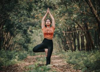 Una mujer practica yoga en el bosque.