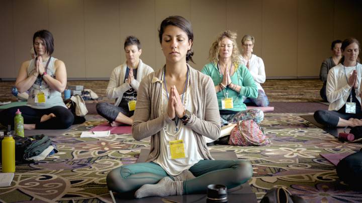 Un grupo de personas aprende a respirar en una clase de yoga.