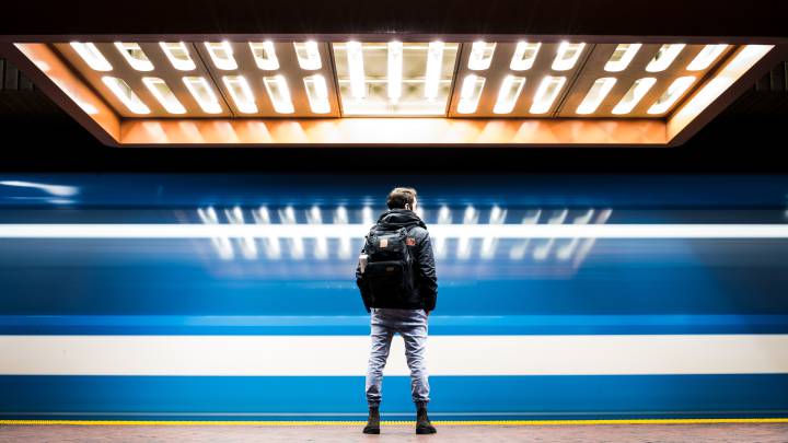 Un hombre espera el tren en su rutina camino del trabajo.
