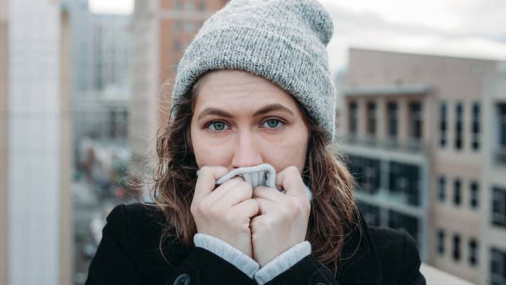 Una mujer se tapa la boca y la nariz por el frío ante el temor a coger un resfriado o la gripe.