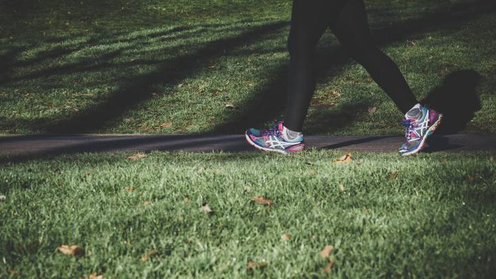 Una mujer camina rápido por el parque para prevenir ciertos tipos de cáncer.