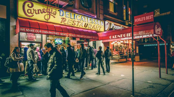 Varias personas hacen cola delante de un restaurante en Nueva York. 